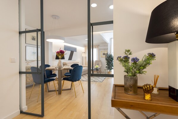 A modern dining area with a wooden table, blue chairs, and a vase of flowers.