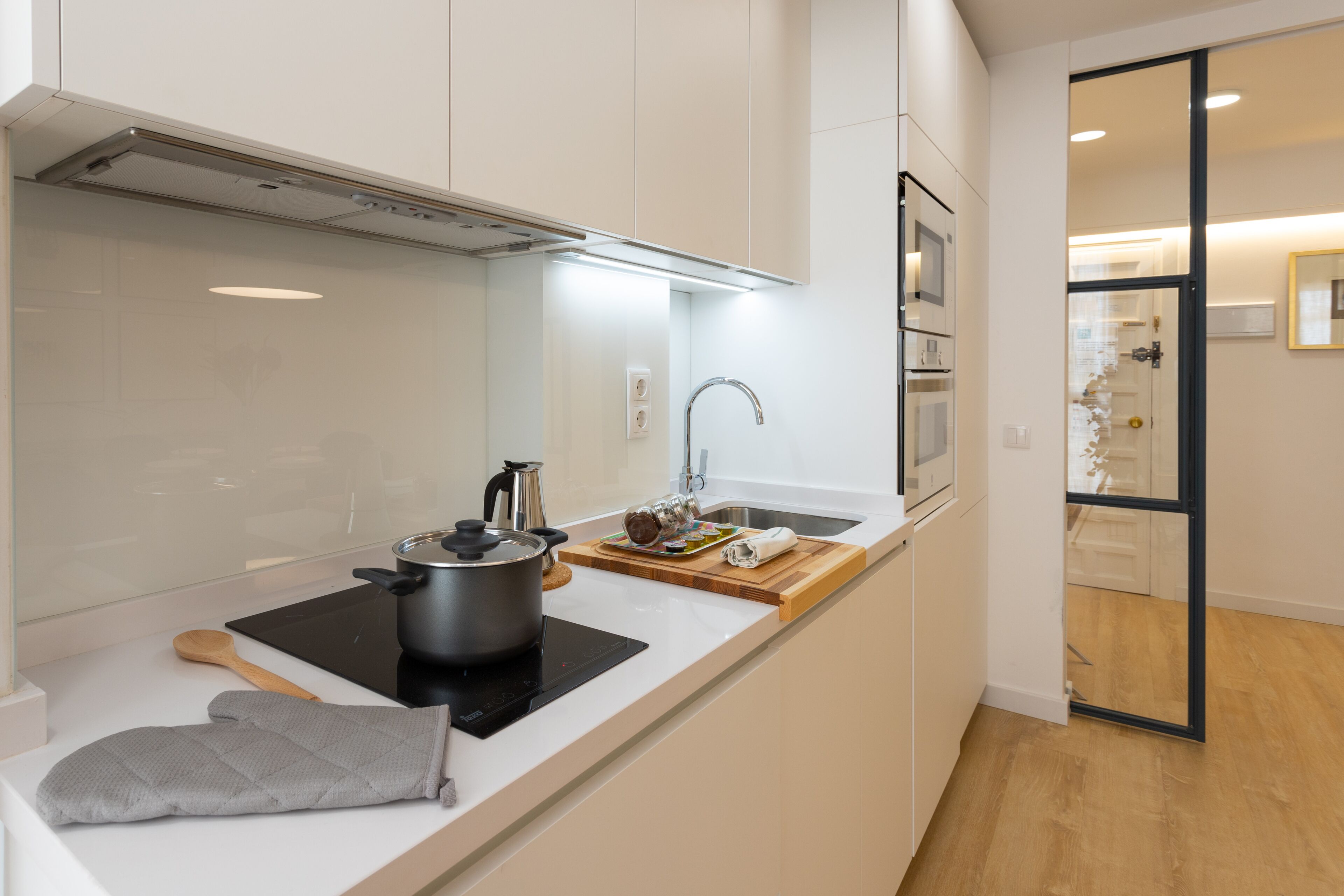 Une cuisine moderne équipée d’une cuisinière, d’un évier et d’une planche à découper en bois.