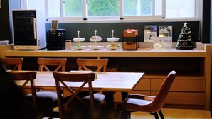 Una cocina con una mesa de comedor y sillas, una cafetera y un pequeño árbol de Navidad.