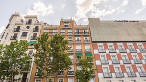 A row of multi-story buildings with balconies and a clear sky.