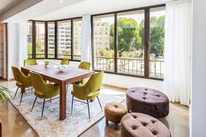 Enjoy meals in this dining area with a wooden table and six chairs, offering a view of the city.