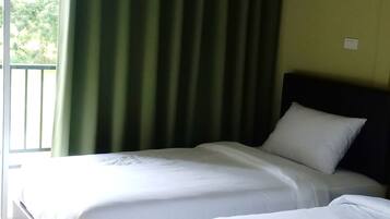 Ein Hotelzimmer mit zwei Betten, einem Balkon und einem grünen Vorhang.