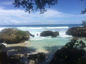 A rocky coastal landscape with clear turquoise waters and waves crashing against the rocks. - Divi's Boutique Retreat (Mangaliliu)