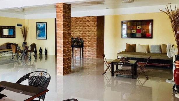 A spacious living area with a modern design, featuring a sofa set, a dining table, and a coffee table. - Evangeline Garden and Lodge (Silang)