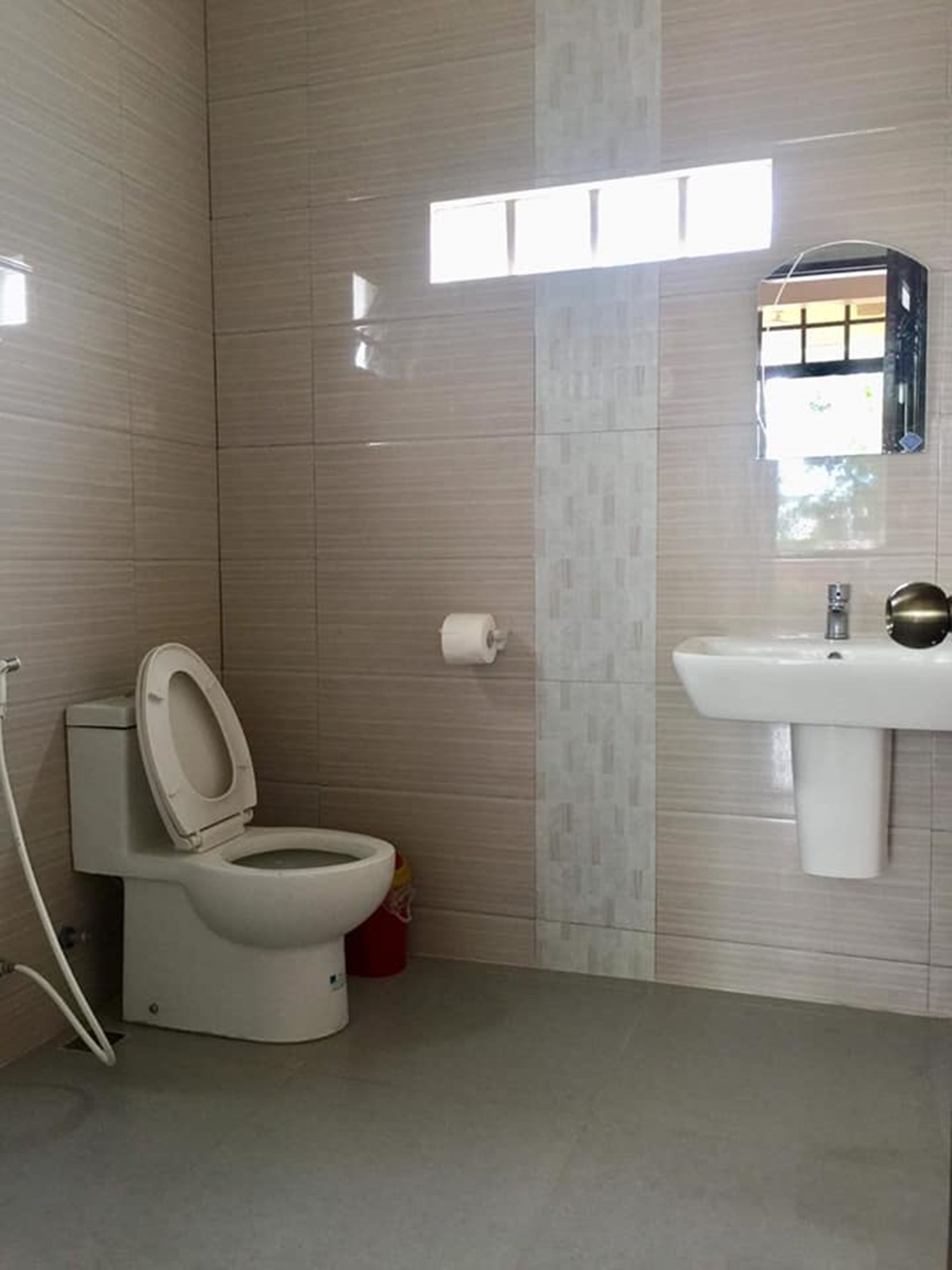 Un baño con inodoro, lavabo y ventana.