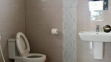 Un baño con inodoro, lavabo y ventana.