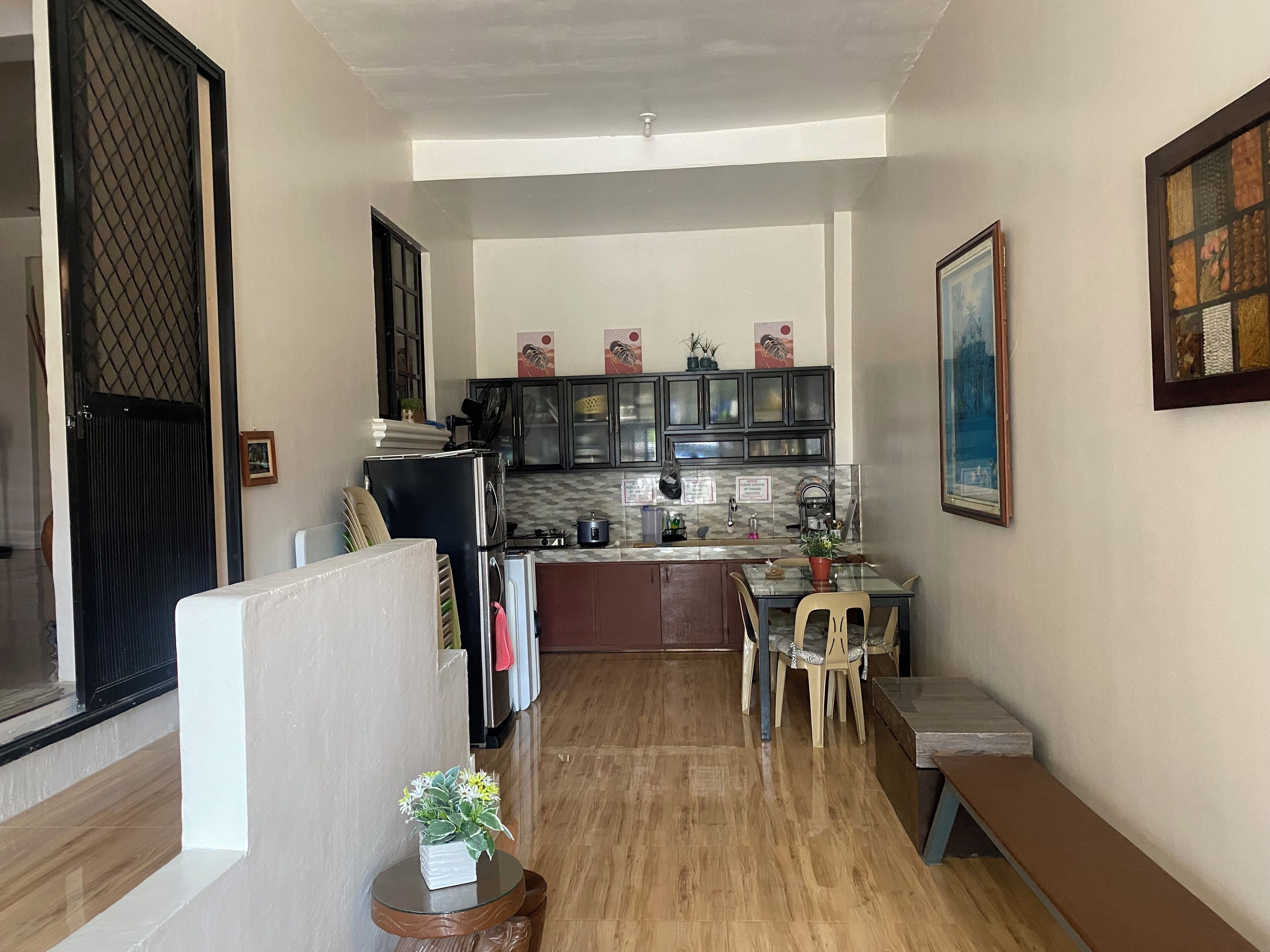 A compact kitchen with a dining area, a small round table, and a bench.