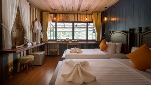 Une chambre avec deux lits, un bureau, une chaise et une fenêtre donnant sur un beau paysage.