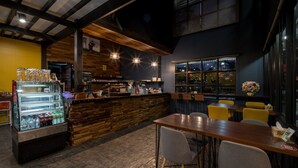 Un restaurant avec un comptoir, un espace pour s’asseoir et un présentoir où sont exposées les boissons.