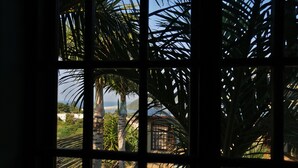 A view through a window with palm trees and a pool. - Villa La Mercy Chalet (La Mercy)