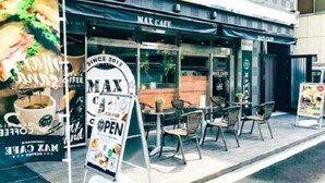 Een Max Cafe met terras en een bord waarop een lunchmenu wordt aangeboden.