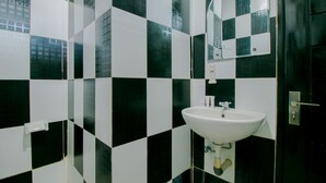 A bathroom with black and white checkered tiles, a white sink, and a mirror above it. - OYO 1014 Bettah Coba 2 Sukabumi (Sukabumi)
