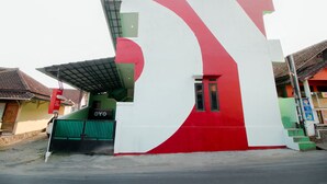 A building with a large, abstract design on its facade, featuring a prominent red and white color scheme. - OYO 1014 Bettah Coba 2 Sukabumi (Sukabumi)