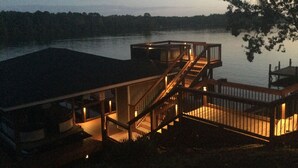 A waterfront property with a wooden deck and stairs leading to a dock. - FREE USE OF OUR 2022 23’ TRITOON EVERY RENTAL DAY
May 1st- Oct 31st (Albemarle)
