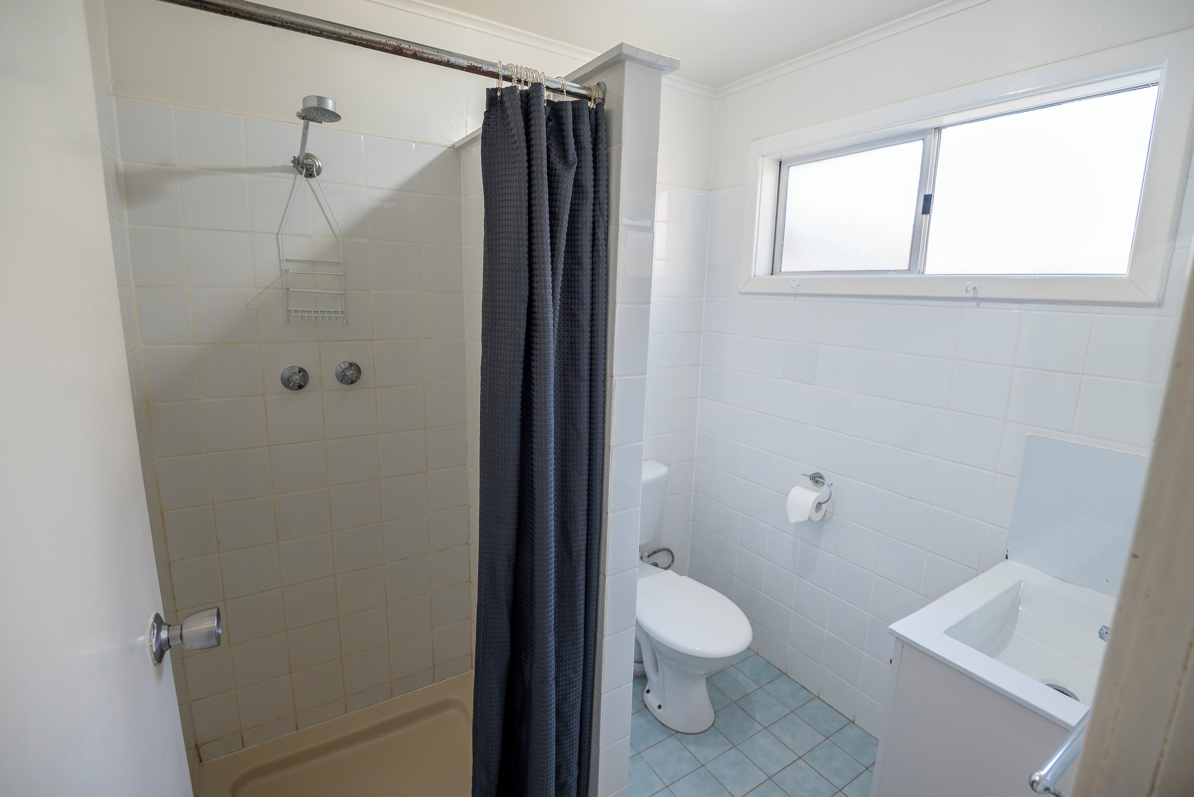 Ein Badezimmer mit Dusche, Toilette und Waschbecken.