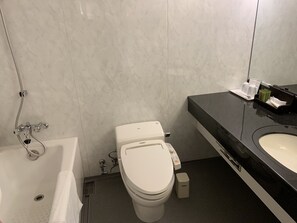 A bathroom with a toilet, sink, and bathtub.