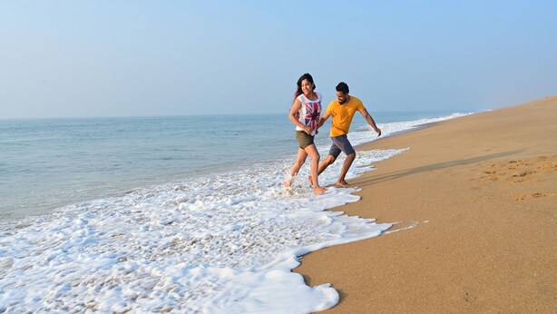 A beach scene with a sandy shore and gentle waves. - Toshali Sands Nature Escape (Puri)
