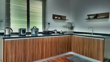 Una cocina moderna con armarios de madera, encimera y ventana con persianas.
