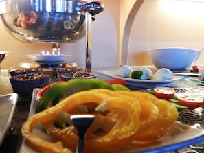 A dining table with various dishes, including a plate of food, a bowl, and a candle. - Berggasthof Hotel Weingarten (Rimsting)
