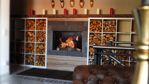 Een open haard met vuur, omringd door houten planken en opgeplakte dierenkoppen.
