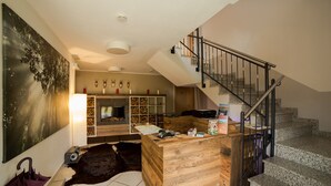 Een moderne woonkamer met een open haard, een houten salontafel en een trap met een metalen leuning.