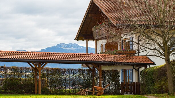 Een chalet met een houten balkon, uitzicht op de bergen en een rustieke uitstraling.