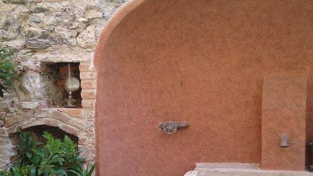 A rustic stone wall with a small window and a stone bathtub. - Residenza Diana (Toscolano Maderno)