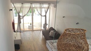 Ein modernes Wohnzimmer mit Treppe, einer Couch und einem Korbwesen.