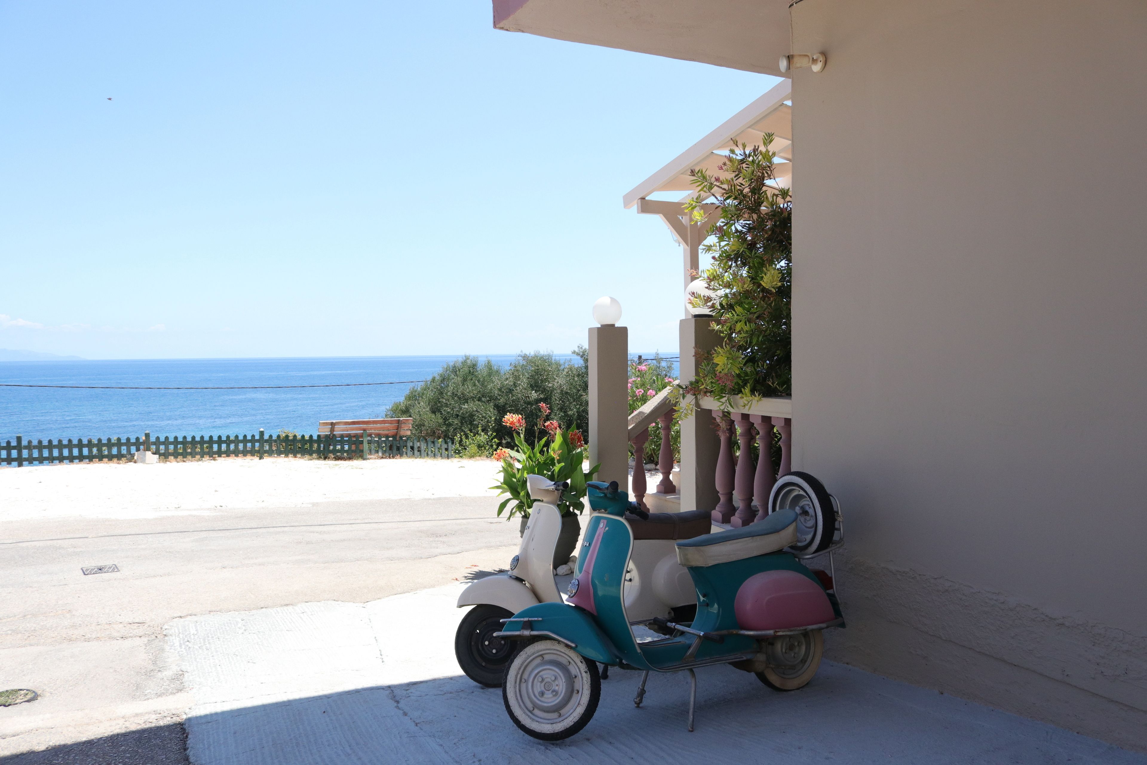 Una scooter aparcada en un balcón con vistas al mar.