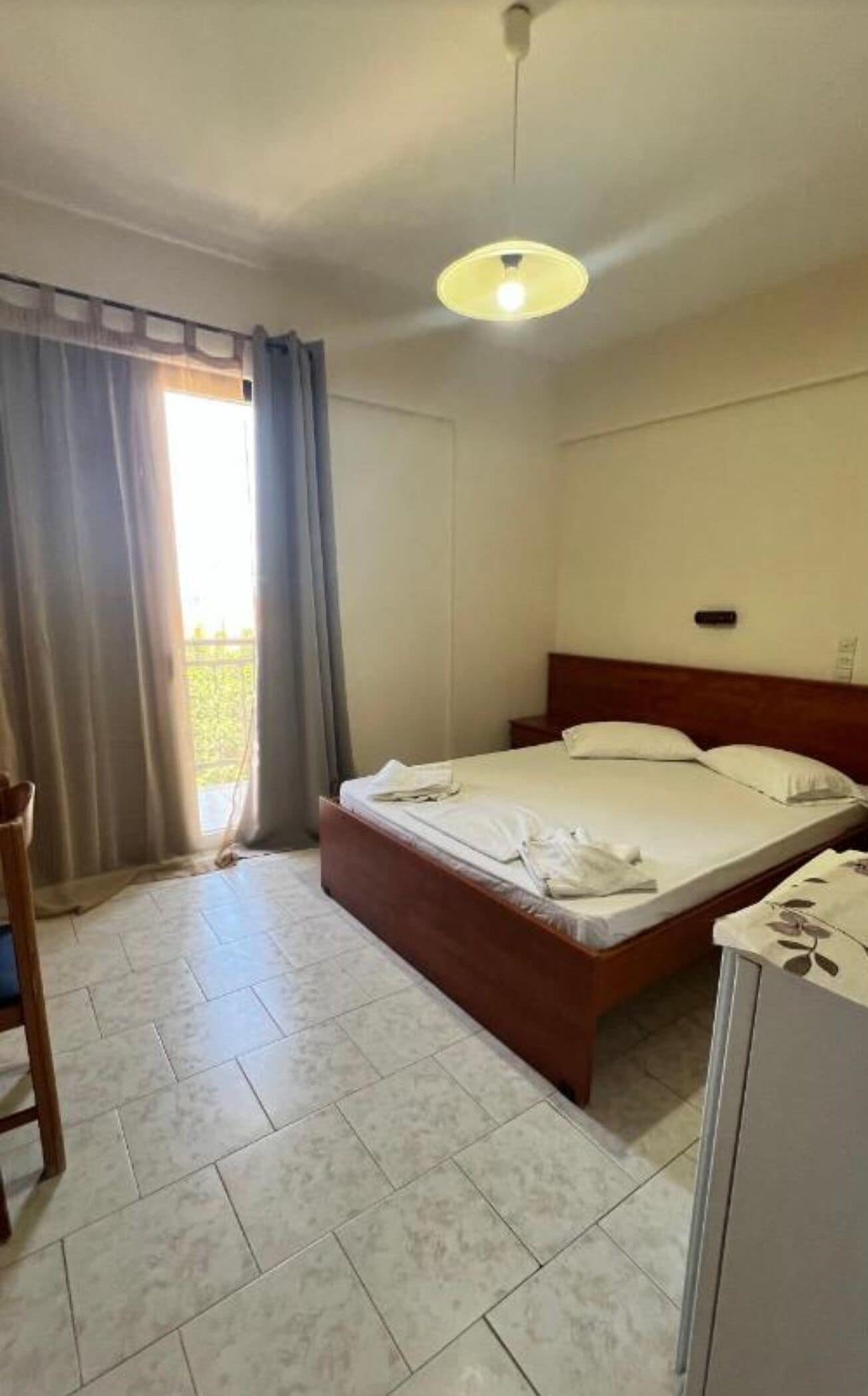 Una camera d'albergo con un letto, una scrivania e una sedia.