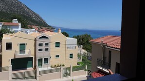 A residential building with a red-tiled roof, a balcony, and a view of the sea. - Michaela (Kefalonia)