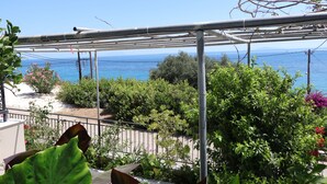 A balcony with a view of the sea, surrounded by greenery and a metal pergola structure. - Michaela (Kefalonia)