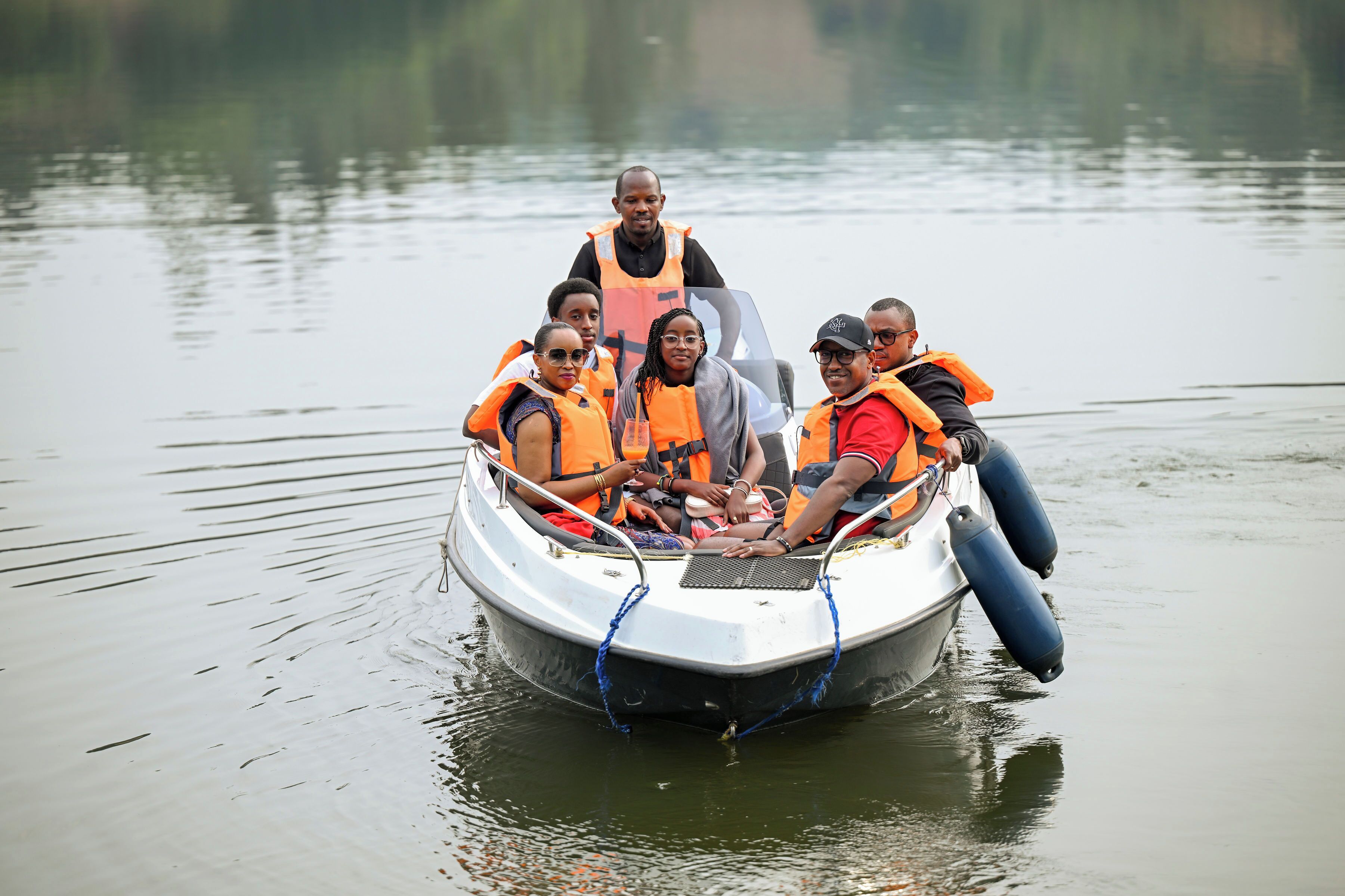 A group of people on a small motorboat wearing life jackets.