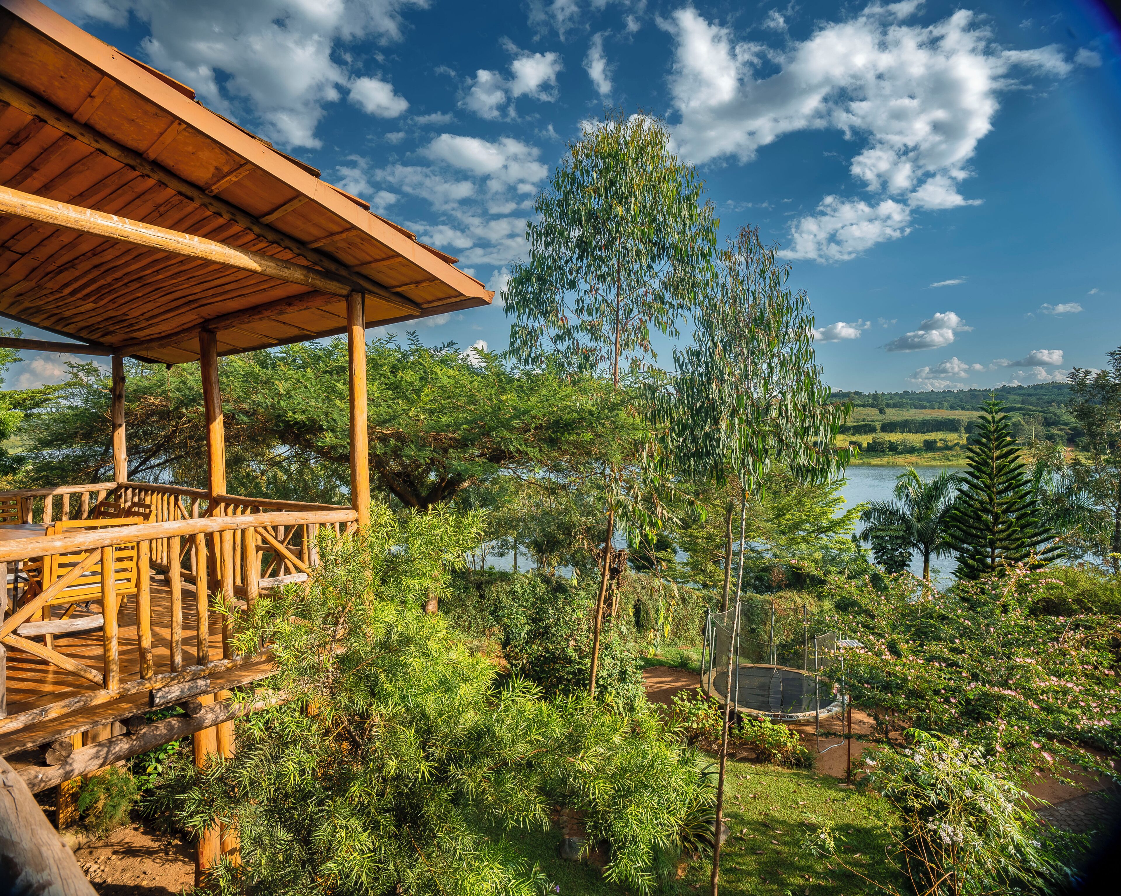 A wooden deck with a view of a lake and surrounding greenery.