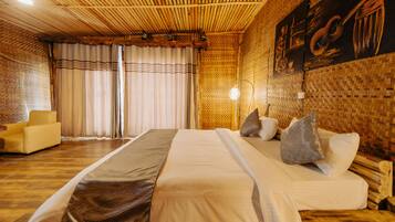 Een kamer met een groot bed, een slaapbank en een muur met een geweven textuur.