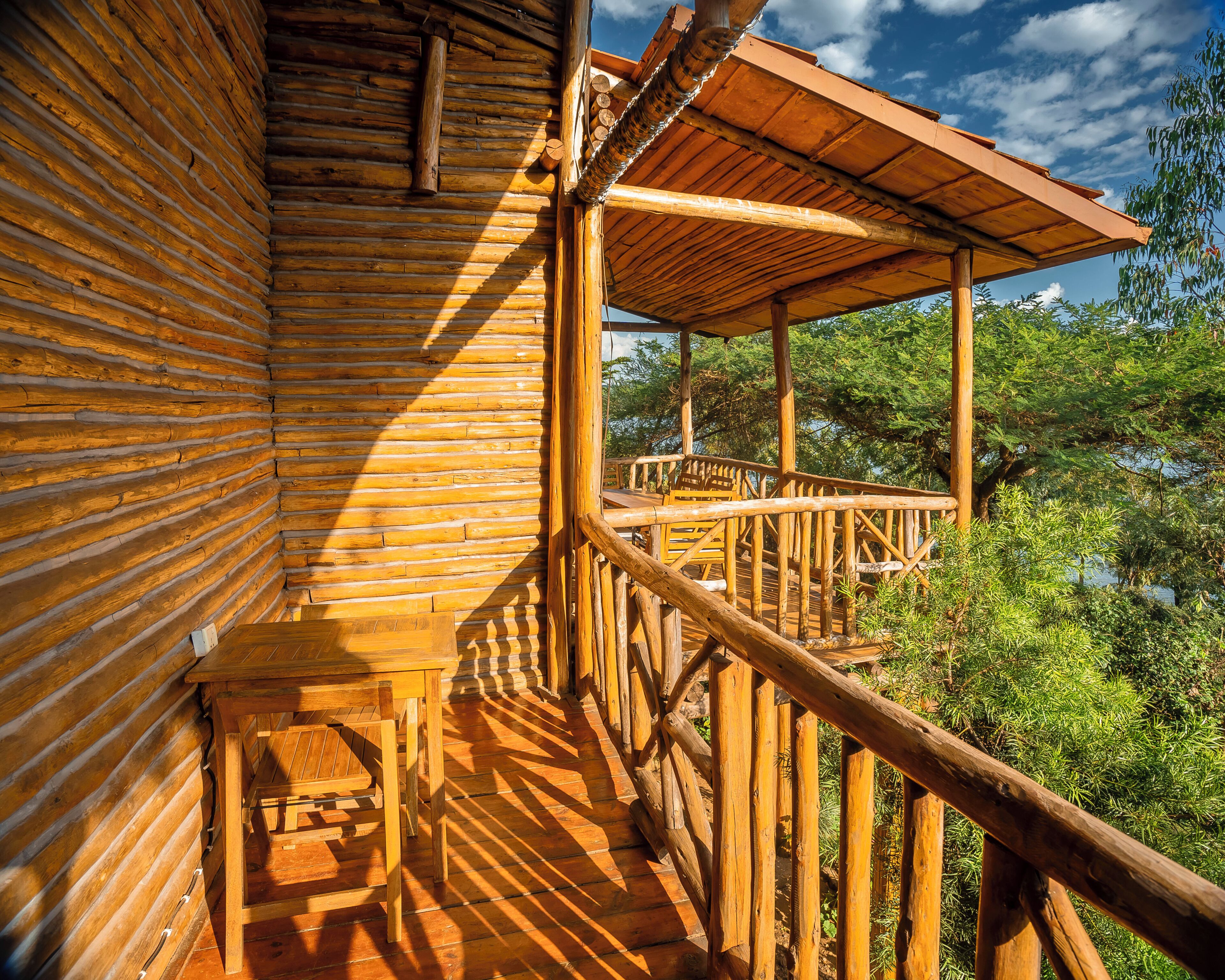 A wooden cabin with a balcony overlooking a natural landscape.