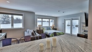 Ein modernes Schlafzimmer mit einem großen Bett, einem Schreibtisch und einem Essbereich mit Stühlen.