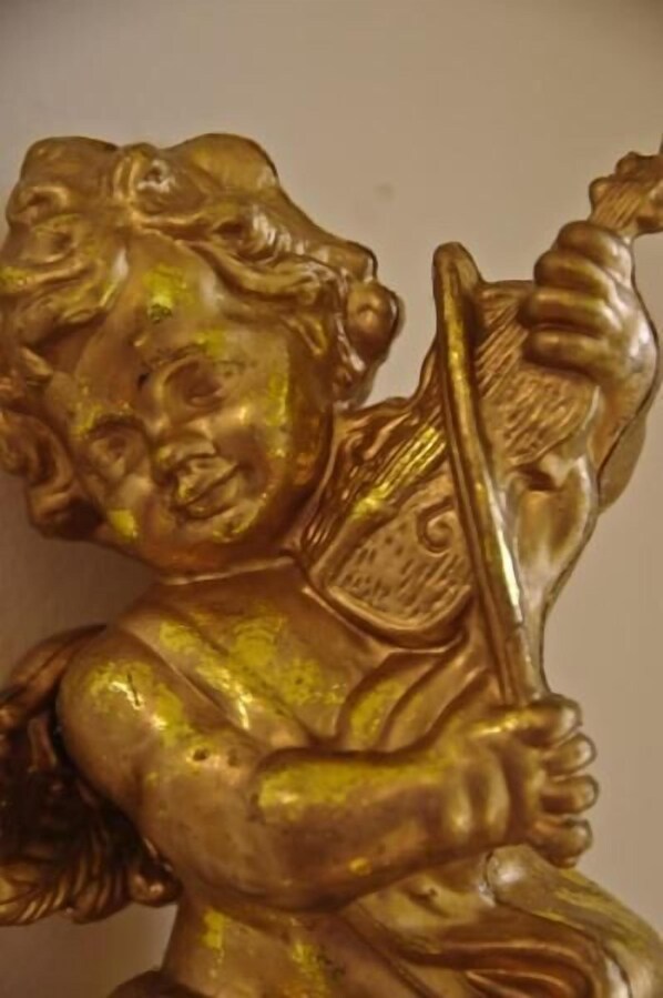 A golden statue of a cherub holding a lyre. - B&B I Cherubini (Cislago)