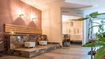 A modern bathroom with a stone countertop, two sinks, and a wooden bench.