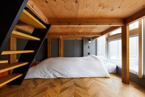 A bedroom with a wooden staircase, a bed with white bedding, and large windows. - HOTEL ORIGO HAKATA - Gion - (Fukuoka)