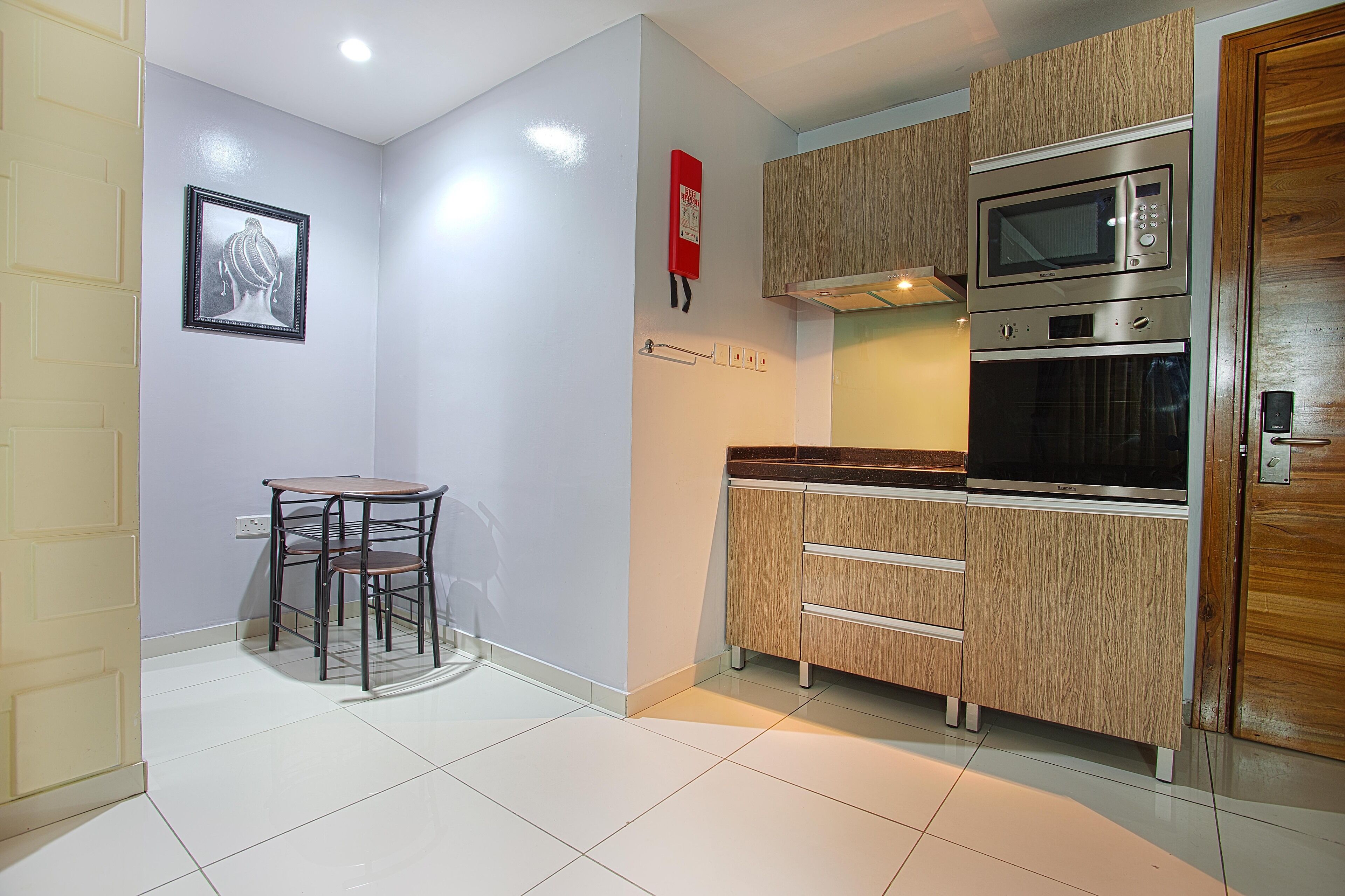 Una cocina compacta con microondas, horno y armarios de madera.
