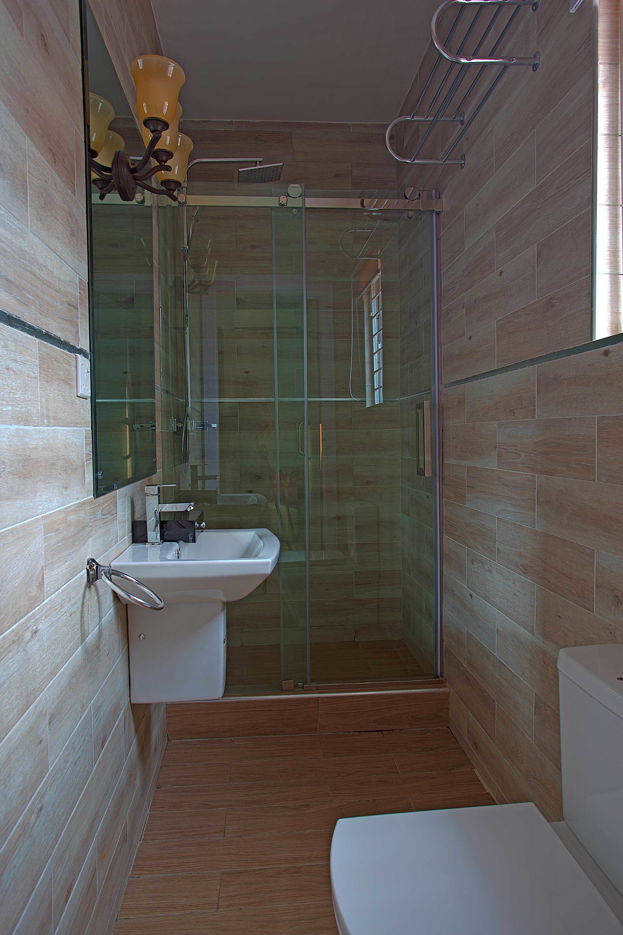 Un bagno con cabina doccia in vetro, lavandino e WC.
