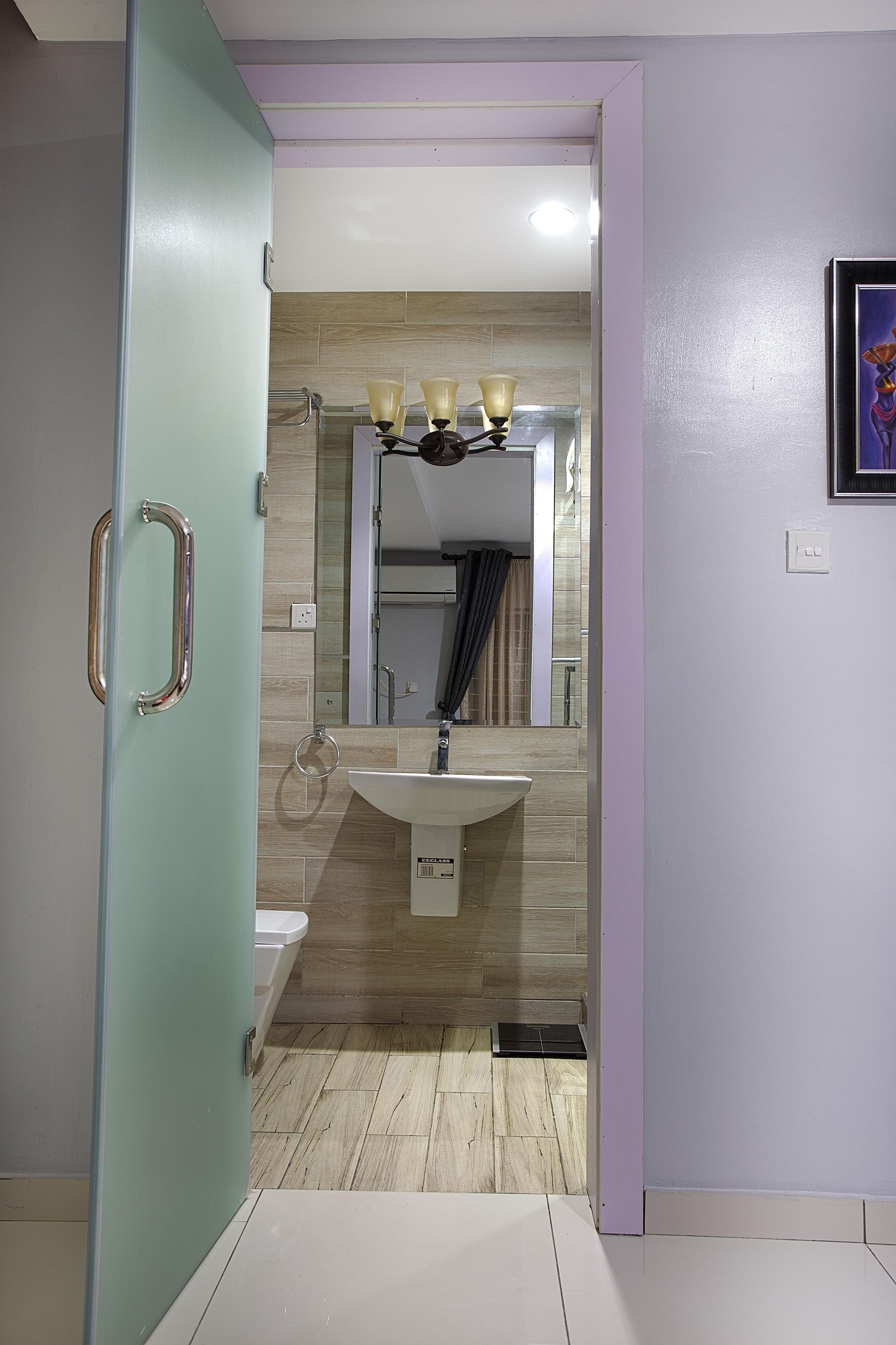 A bathroom with a sink, mirror, and handrail.