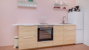Une cuisine moderne dotée d’un four encastré, de meubles blancs et d’un réfrigérateur blanc.