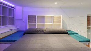 A bedroom with a bed, a window with blinds, a white wardrobe, and a ceiling with recessed lighting. - Holiday Apartment in Genova Fieno (Genoa)