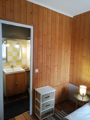 Enjoy a warm and inviting bathroom with a sink, mirror, and practical storage options.
