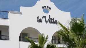 En byggnad med en skylt där det står ”La Villa” och en dekorativ portal.