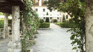 Un sendero de piedra que conduce a un edificio de fachada blanca y un vestíbulo cubierto.