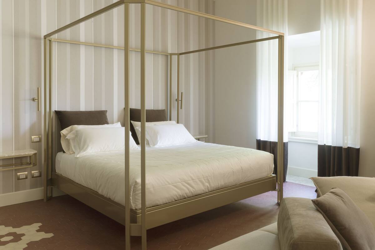 A four-poster bed with a headboard, a bedside table, and a nightstand.