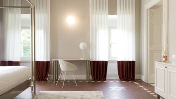 Um quarto com cama, escrivaninha, cadeira, tapete e guarda-roupa.